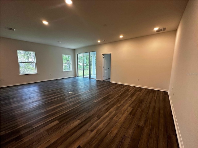 unfurnished room with dark wood-type flooring