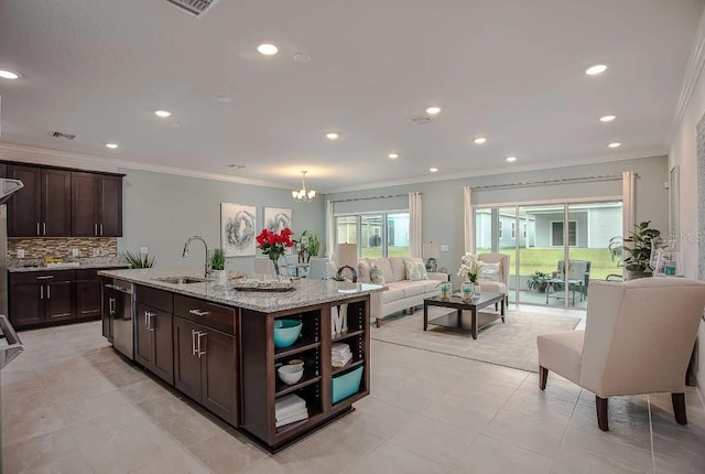 kitchen featuring sink, dishwasher, a kitchen island with sink, dark brown cabinetry, and light stone countertops