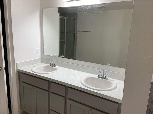 bathroom featuring a shower with door and vanity