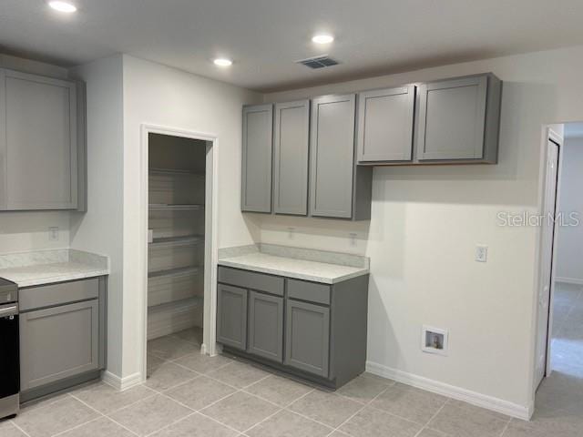 kitchen with gray cabinetry and light tile patterned floors