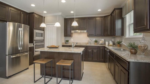 kitchen with sink, stainless steel appliances, a center island, dark brown cabinetry, and decorative light fixtures