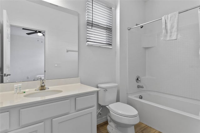 full bathroom with ceiling fan, bathing tub / shower combination, toilet, oversized vanity, and hardwood / wood-style flooring