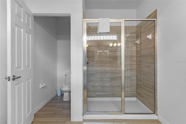 bathroom featuring toilet, walk in shower, and hardwood / wood-style flooring