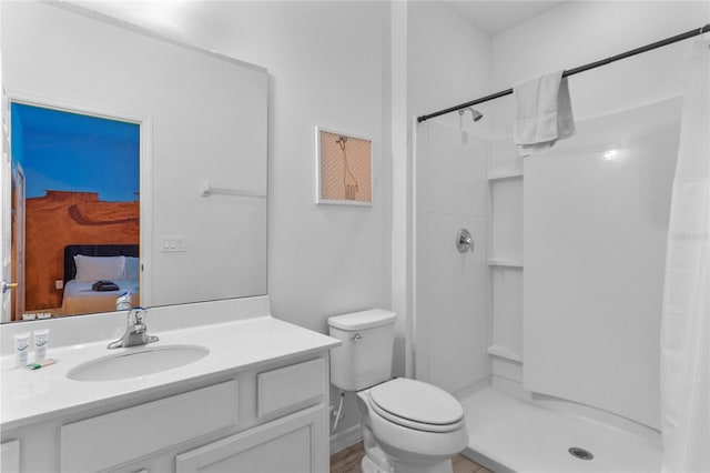 bathroom with walk in shower, toilet, and vanity