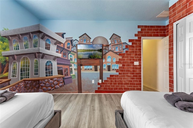 bedroom with hardwood / wood-style floors and a textured ceiling