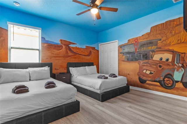 bedroom featuring a closet, light hardwood / wood-style floors, and ceiling fan