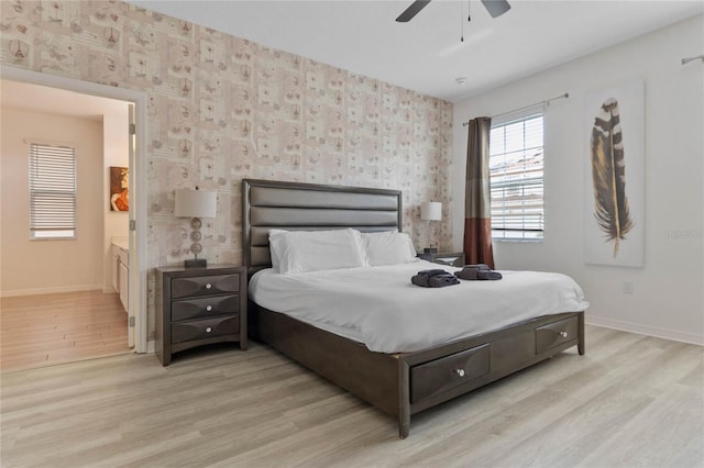 bedroom featuring ensuite bath, ceiling fan, and light wood-type flooring