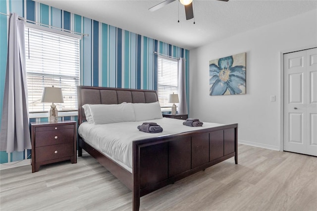 bedroom featuring multiple windows, ceiling fan, and light hardwood / wood-style flooring