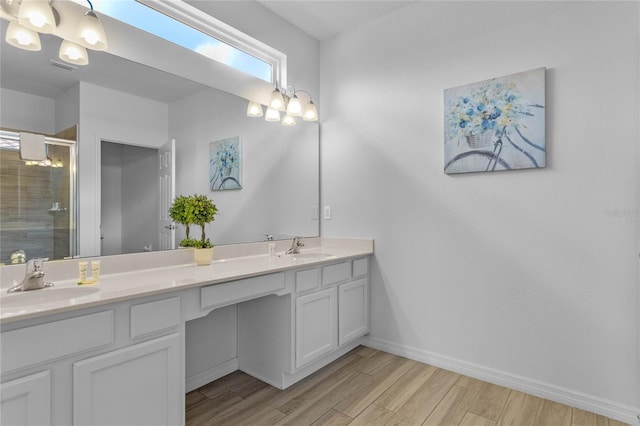 bathroom with a shower with shower door, wood-type flooring, and dual bowl vanity