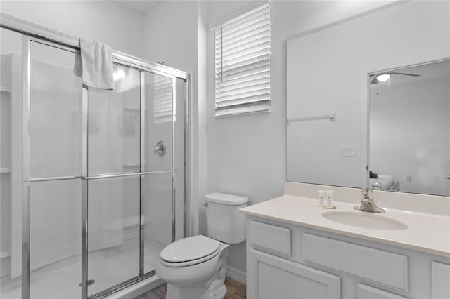 bathroom featuring toilet, a shower with door, and vanity