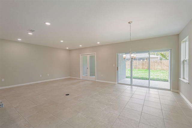 spare room with light tile patterned floors and a chandelier