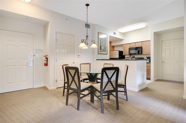 dining space with light colored carpet and a chandelier