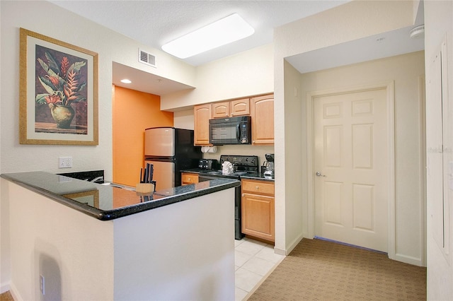 8100 Poinciana Blvd Unit 2212, Orlando, FL 32821 - kitchen with black appliances, dark countertops, a peninsula, and light brown cabinets
