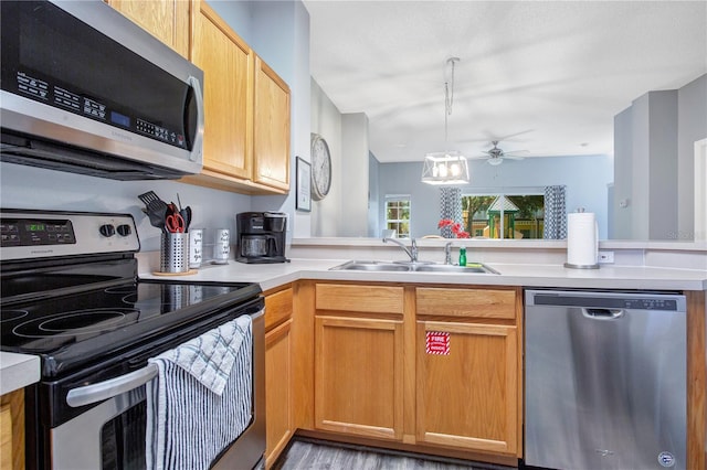 kitchen featuring appliances with stainless steel finishes, kitchen peninsula, ceiling fan, and sink