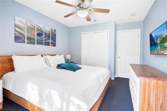 bedroom with a closet, dark colored carpet, and ceiling fan