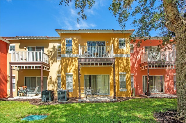 rear view of property with a balcony, a patio area, and central AC unit