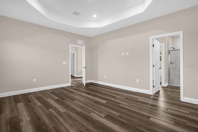 empty room featuring dark hardwood / wood-style floors and a tray ceiling