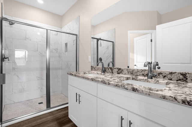 bathroom featuring walk in shower, wood-type flooring, and dual vanity