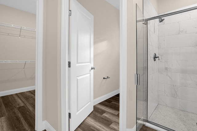 bathroom with a shower with shower door and wood-type flooring