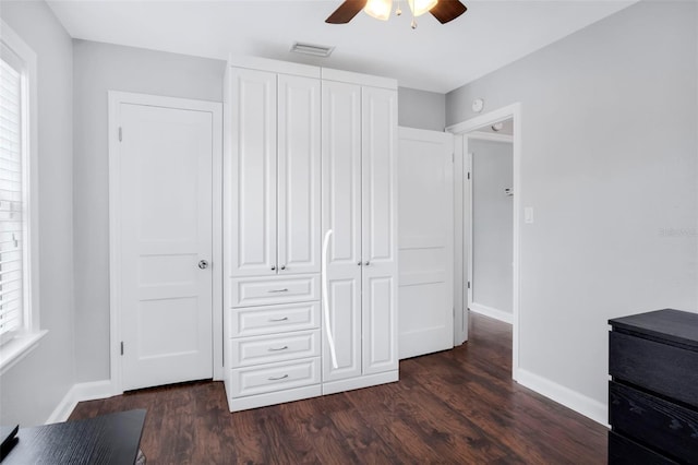 unfurnished bedroom featuring dark hardwood / wood-style flooring, a closet, and ceiling fan