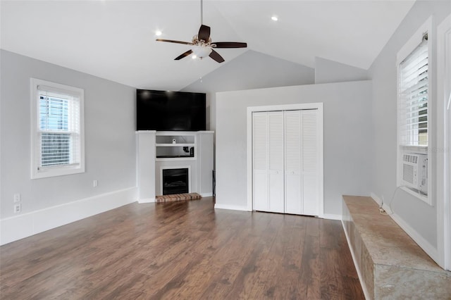 unfurnished living room featuring lofted ceiling, dark hardwood / wood-style flooring, ceiling fan, and a fireplace