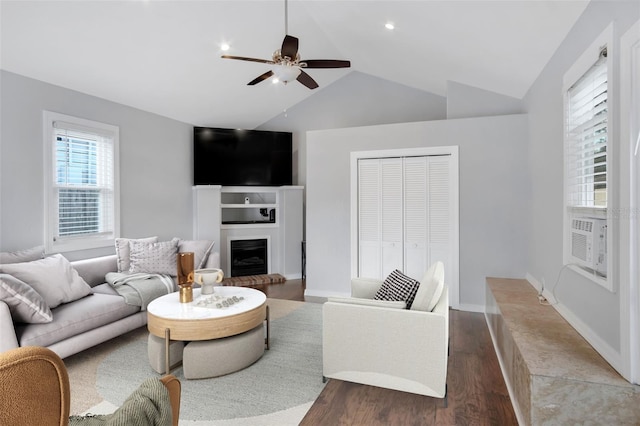 living room featuring ceiling fan, a fireplace, vaulted ceiling, and dark wood-type flooring