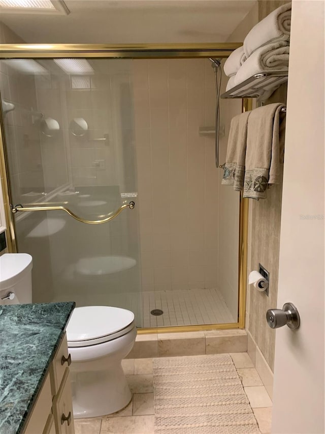 bathroom with an enclosed shower, vanity, tile flooring, and toilet