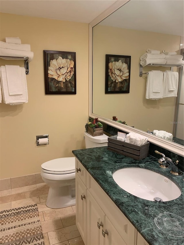 bathroom featuring oversized vanity, toilet, and tile floors