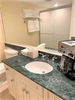 bathroom featuring vanity, tile floors, and toilet