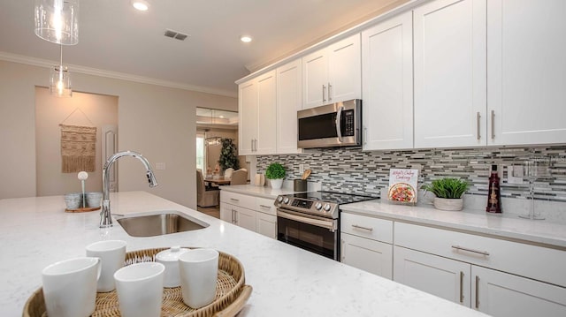 kitchen with sink, light stone countertops, white cabinets, and appliances with stainless steel finishes