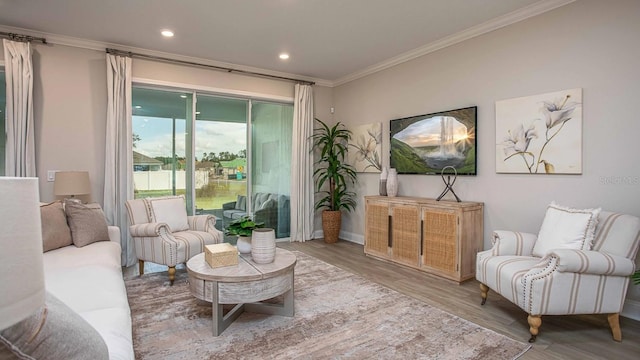 living area with hardwood / wood-style floors and ornamental molding