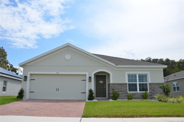 view of front of home with solar panels, a front lawn, and a garage