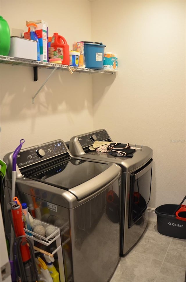 washroom with washing machine and dryer and light tile floors