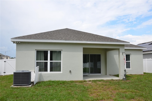 back of house with a lawn, a patio, solar panels, and central air condition unit