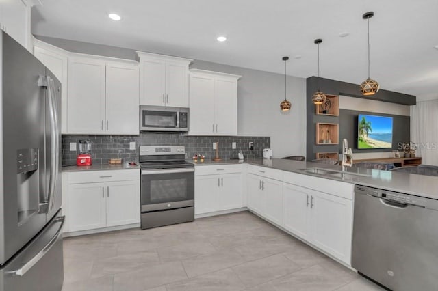 kitchen with decorative light fixtures, light tile flooring, appliances with stainless steel finishes, backsplash, and sink