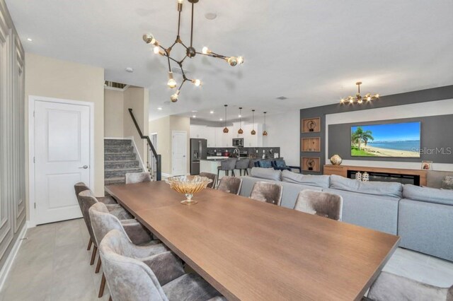 dining room featuring light tile floors and a chandelier