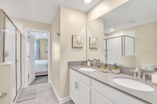 bathroom with double vanity, toilet, tile floors, and a shower with shower door