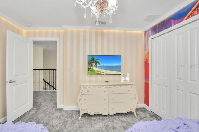 carpeted bedroom featuring a closet and a chandelier