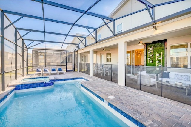 view of pool with an in ground hot tub, ceiling fan, a patio, and a lanai