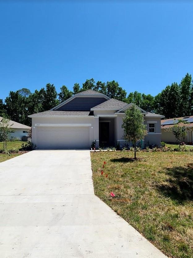 ranch-style house featuring a garage and a front yard