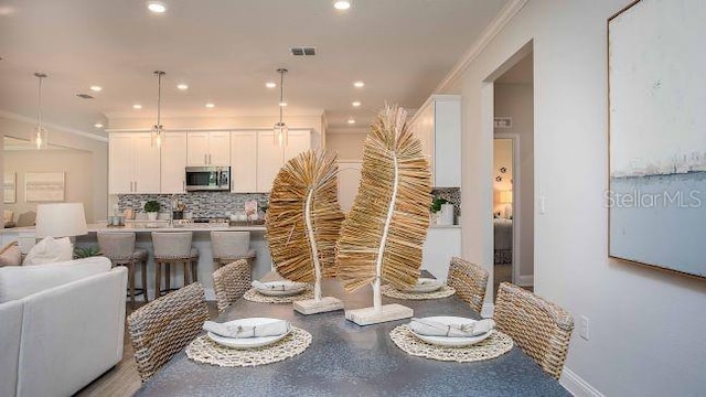 dining space featuring visible vents, ornamental molding, and recessed lighting