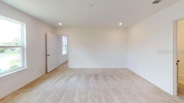 carpeted spare room featuring a healthy amount of sunlight