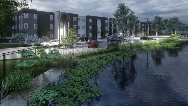 view of home's community with a water view and fence