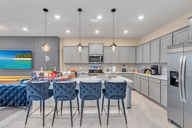 kitchen with decorative light fixtures, tasteful backsplash, light tile flooring, and stainless steel appliances