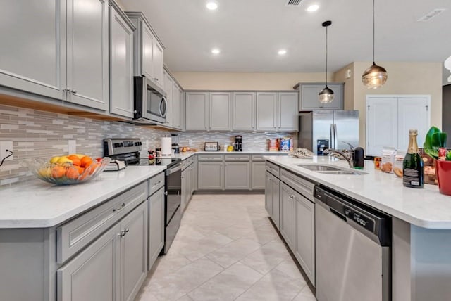 kitchen with decorative light fixtures, backsplash, appliances with stainless steel finishes, light tile floors, and gray cabinets