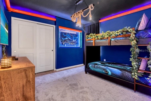 carpeted bedroom with a closet and a notable chandelier