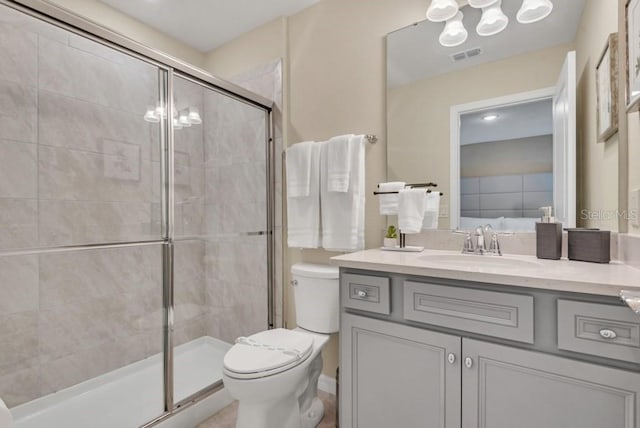 bathroom featuring toilet, a shower with door, and vanity with extensive cabinet space