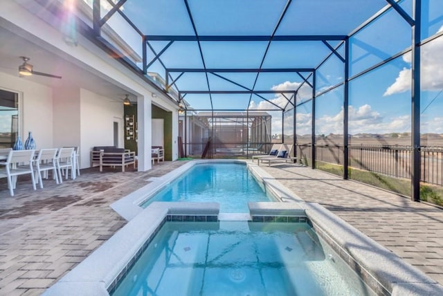 view of swimming pool with an in ground hot tub, ceiling fan, glass enclosure, and a patio