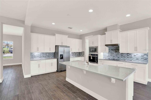 kitchen featuring white cabinetry, stainless steel appliances, an island with sink, and dark wood-type flooring