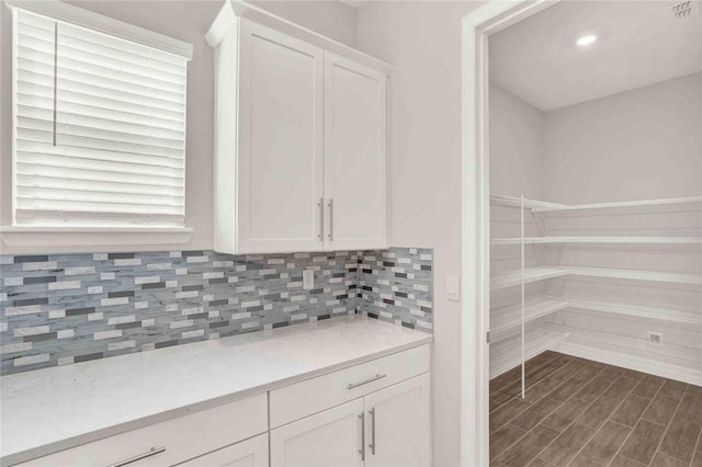 interior space featuring dark hardwood / wood-style flooring, white cabinetry, and plenty of natural light